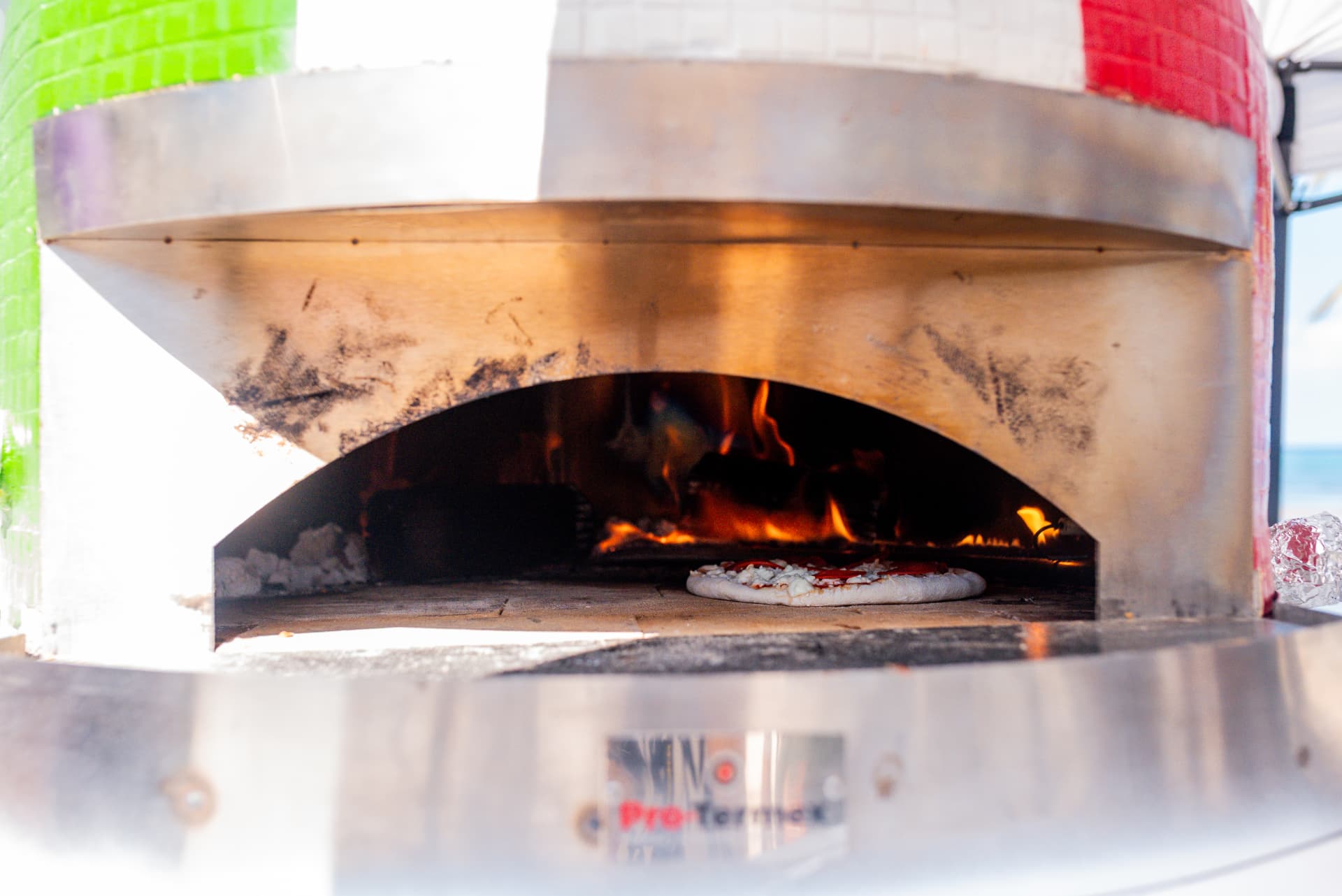 Pizza baking inside the Dama Pizza Experience gas and wood-fired oven